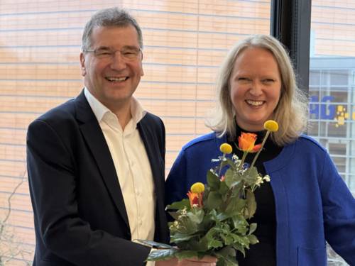 Herr von Helden überreicht Frau Schach einen Blumenstrauß