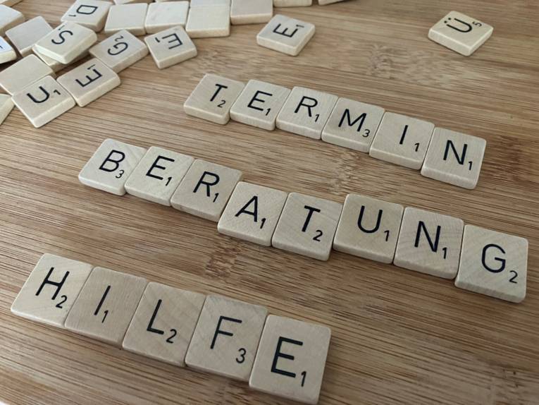 Aus Buchstaben gelegt die Wörter: Termin - Beratung - Hilfe